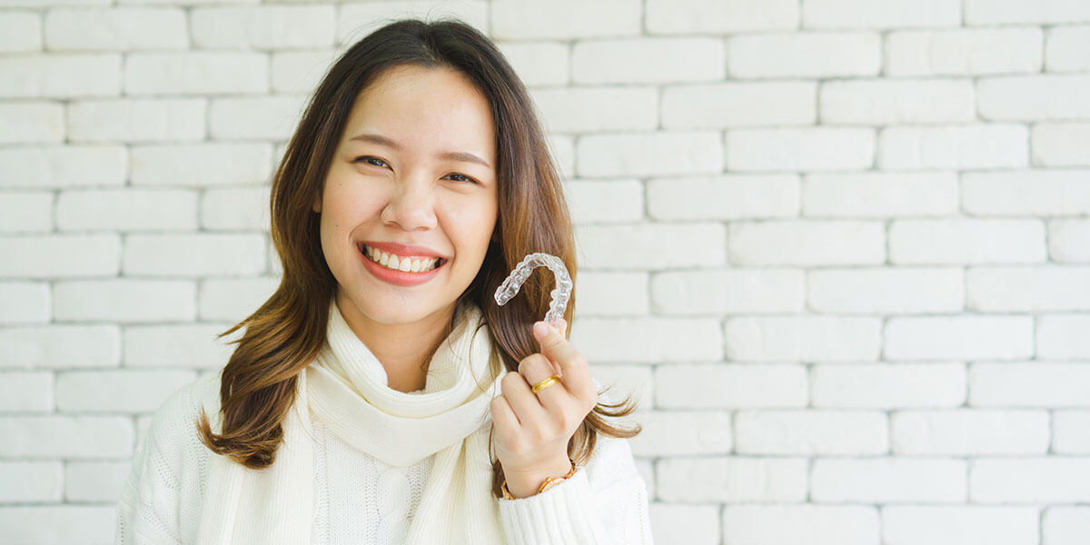 woman holding clean dental aligner