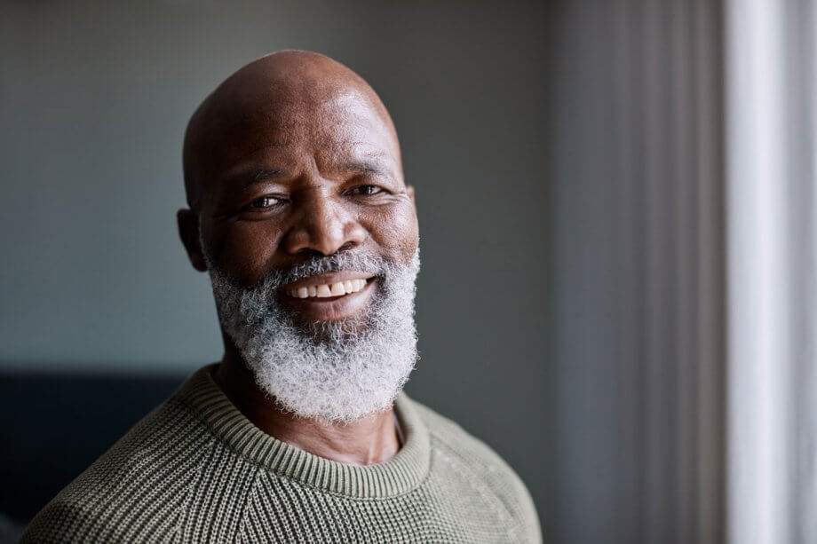 close up of smiling older man with beard and bald head