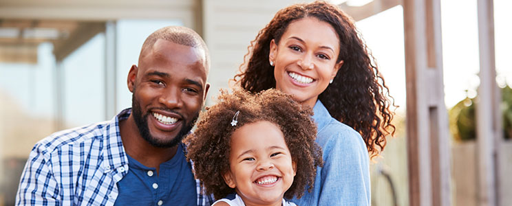 mom, dad and young daughter, smiling