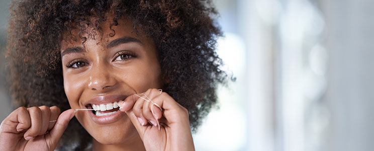 young woman flossing her teeth