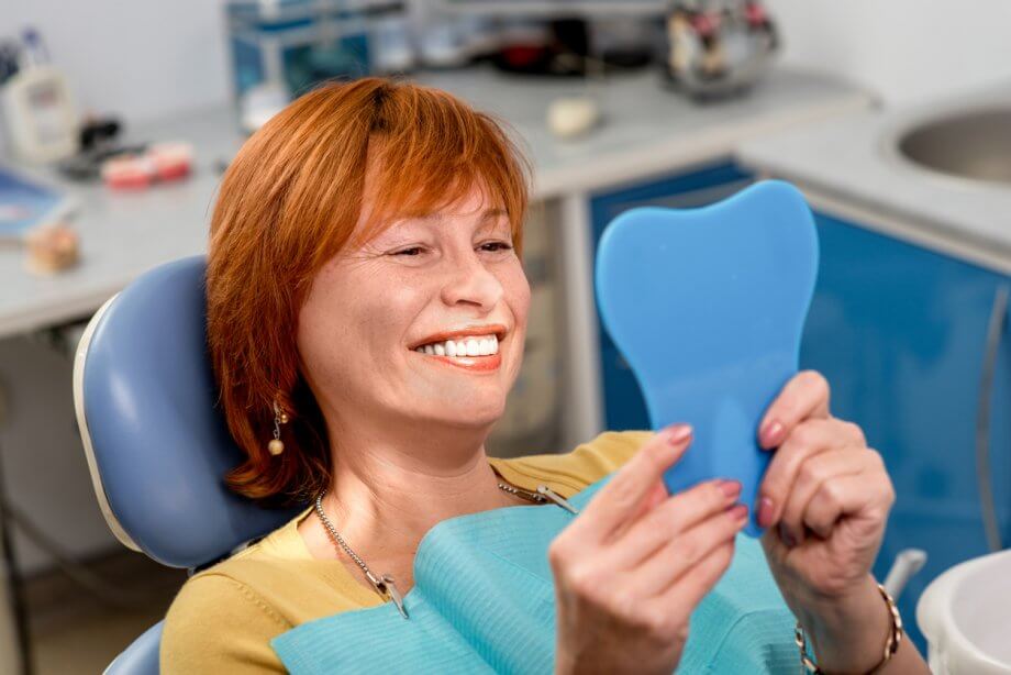 woman examining teeth at dentist