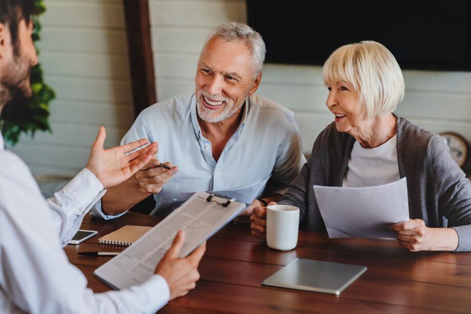 senior couple talking with man at table